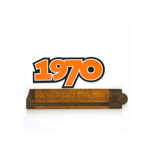 Die cut vinyl sticker reading photographed with a ruler for scale “1970” in bold font, measuring 4.5" x 2", inspired by Iggy and the Stooges.
