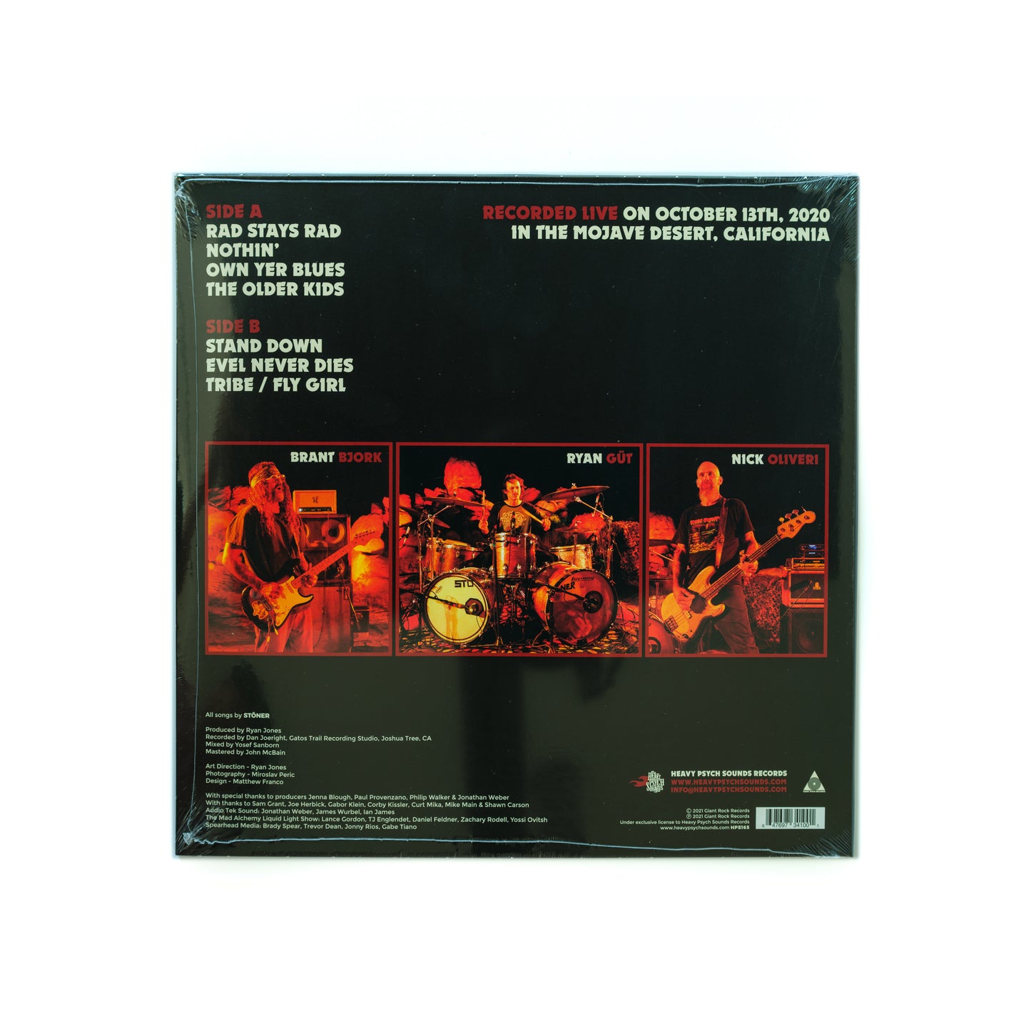 Back cover of Stöner – Live In The Mojave Desert Volume 4 LP, showing live performance shots of Brant Bjork, Nick Oliveri, and Ryan Güt, along with tracklist, credits, and Mojave Desert Sessions branding—highlighting the raw, fuzzed-out desert rock power of this live recording.