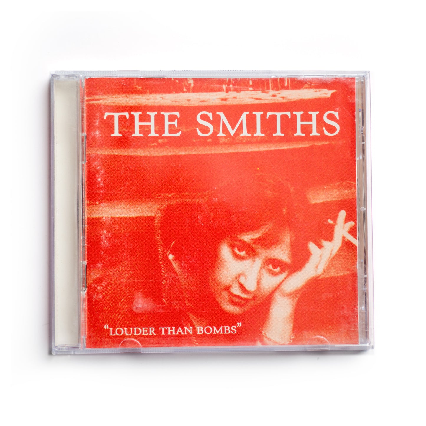 Front cover of The Smiths Louder Than Bombs CD featuring orange-toned photo of actress Shelagh Delaney, iconic 1987 compilation album cover, alternative rock music, 80s British band, Morrissey and Johnny Marr, Rough Trade Records release.