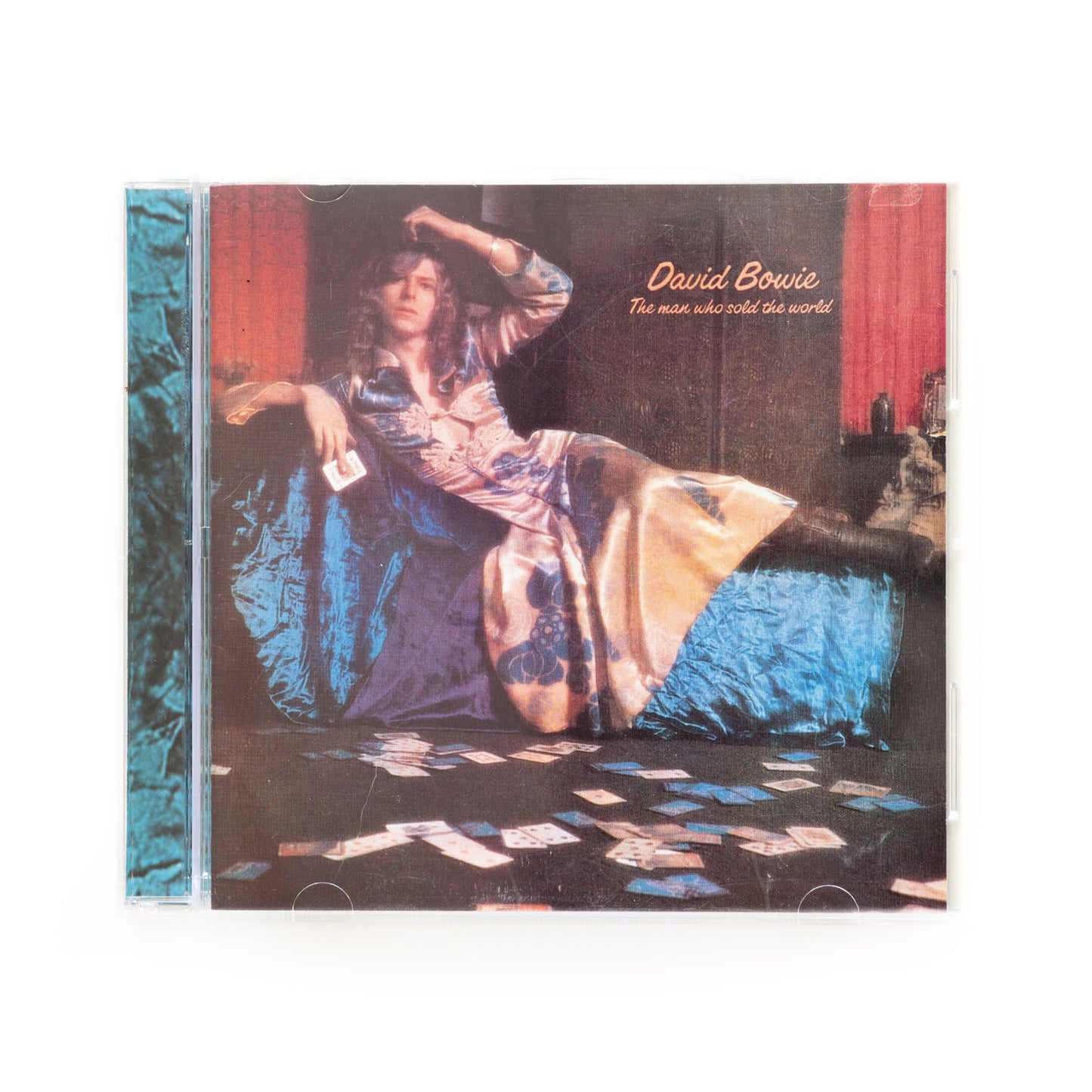 CD cover of David Bowie's 'The Man Who Sold the World' with the artist sitting on a bed.