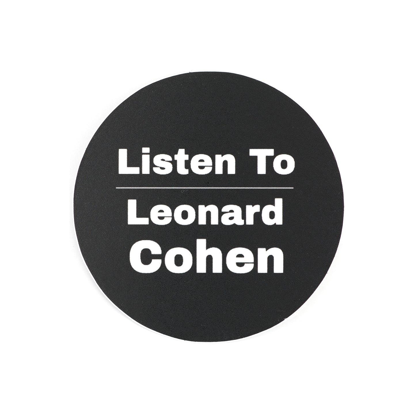 Photo of three inch round, black sticker with white writing that reads, Listen To Leonard Cohen.