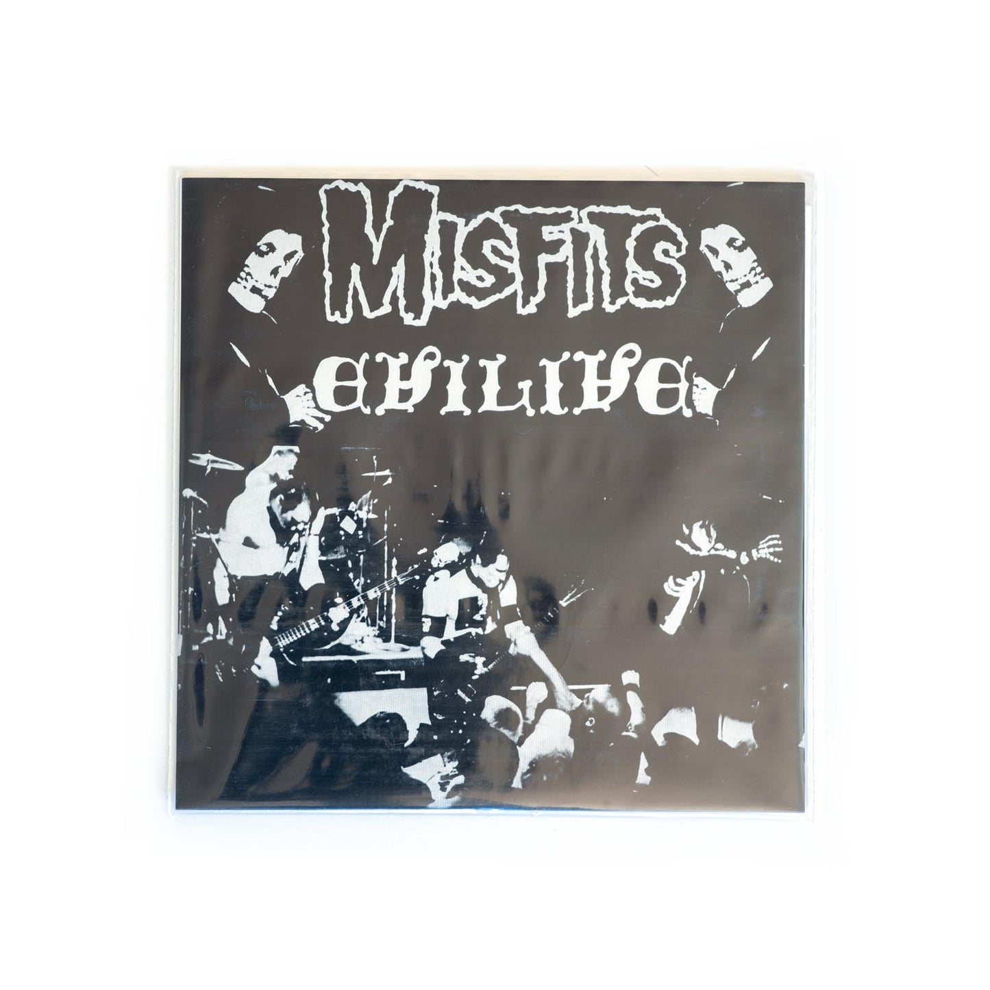 Album cover for 'Misfits Evilive' 7 inch with black and white photo of the band performing live. Glenn Danzig, Jerry Ony, and Doyle.