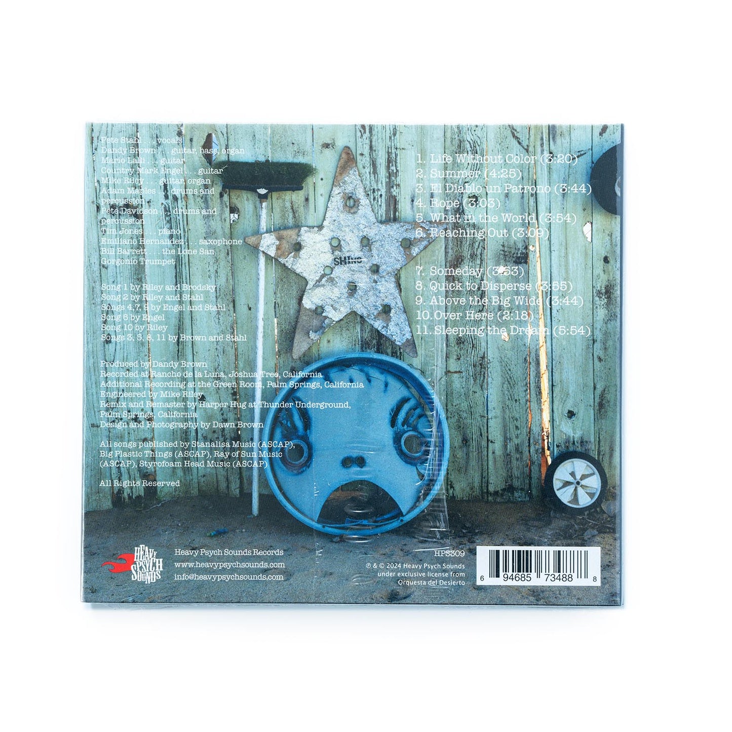 Back cover of Orquesta Del Desierto – Dos CD showcasing full tracklist, band member credits, and label information; clean layout with desert-themed design elements that mirror the album’s atmospheric blend of Latin rock, acoustic textures, and psychedelic soundscapes.