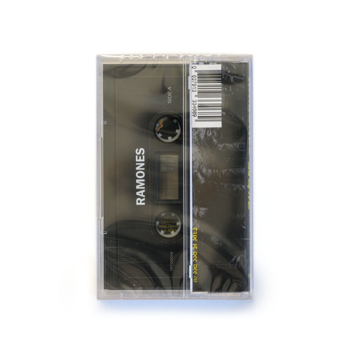 Back cover of The Ramones Buzz Off! Cassette tape. The cassette is black with a white Ramones logo printed on the tape. Tape it Dee Dee 018 is on the J Card.