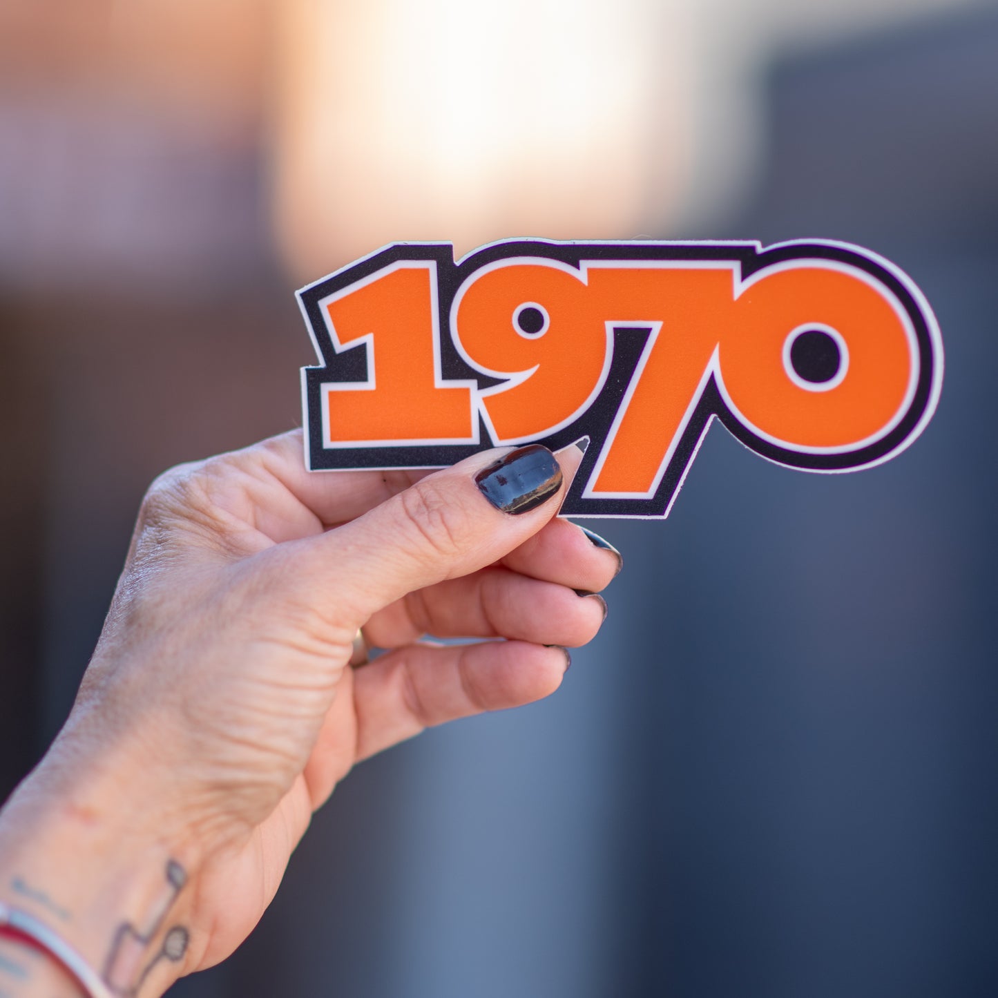 The Stooges 1970 Sticker held by a woman's hand. 