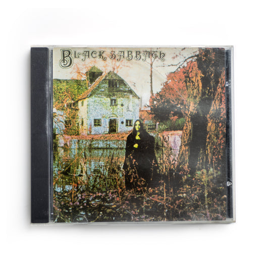 Front cover of Black Sabbath self-titled CD featuring eerie image of cloaked figure in front of a haunted mill, classic 1970 heavy metal debut, iconic album artwork with gothic tones, Vertigo/Warner Bros. release, Ozzy Osbourne and Tony Iommi.