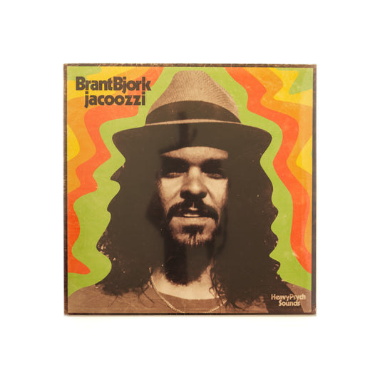 Front cover of Brant Bjork – Jacoozzi vinyl LP, featuring vintage-style artwork with a blurred, lo-fi image of Brant Bjork —channeling 1970s funk, psychedelic soul, and laid-back California vibes.