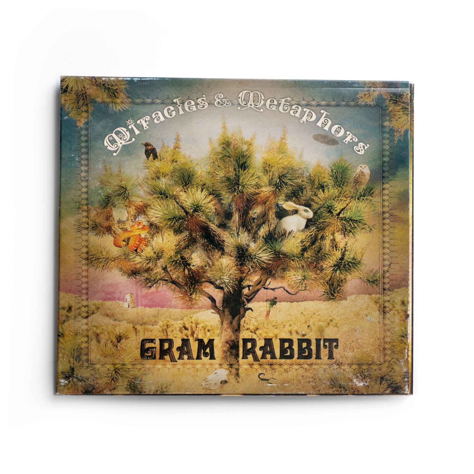 Front cover of Gram Rabbit Miracles and Metaphors CD featuring surreal, abstract artwork with soft color tones and geometric shapes, 2006 album by electronic indie rock band Gram Rabbit, includes tracks like 'Time of Our Lives' and 'Candy Flip.'