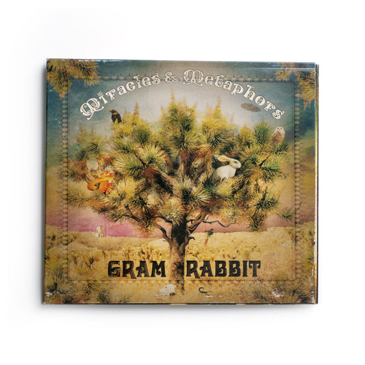 Front cover of Gram Rabbit Miracles and Metaphors CD featuring surreal, abstract artwork with soft color tones and geometric shapes, 2006 album by electronic indie rock band Gram Rabbit, includes tracks like 'Time of Our Lives' and 'Candy Flip.'