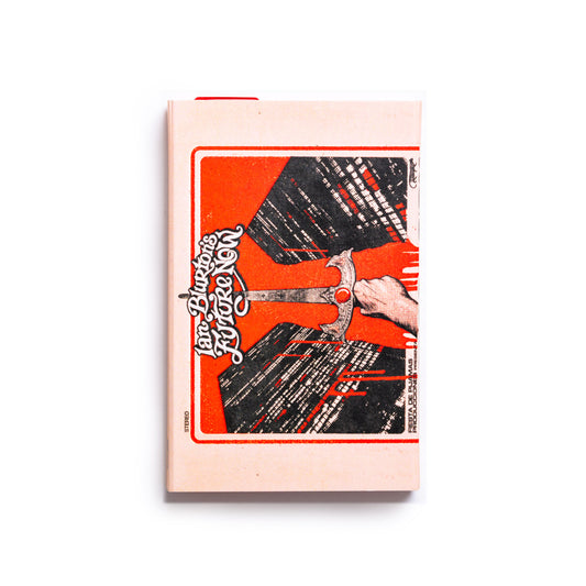 Cassette tape of Ian Blurton's Future Now Crimes of the City cover with a stylized illustration of a hand holding a sword against skyscrapers on an orange background