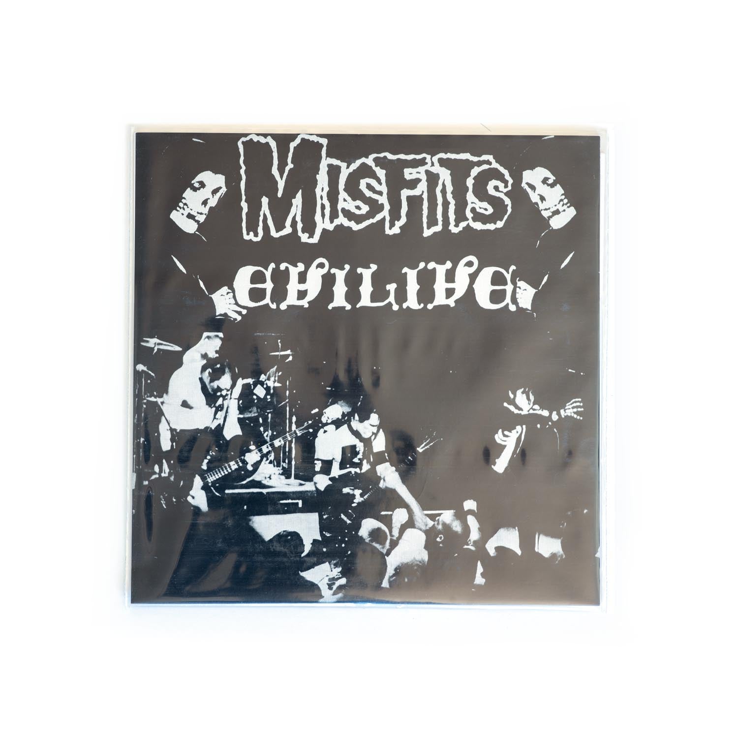 Album cover for 'Misfits Evilive' 7 inch with black and white photo of the band performing live. Glenn Danzig, Jerry Ony, and Doyle. 