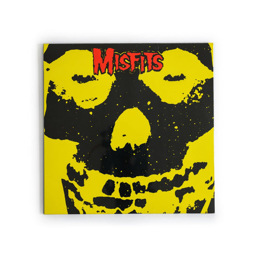 Misfits – Misfits album cover featuring the iconic crimson skull logo on a stark yellow background, with bold red “Misfits” text in distressed punk font; a defining image of horror punk culture.