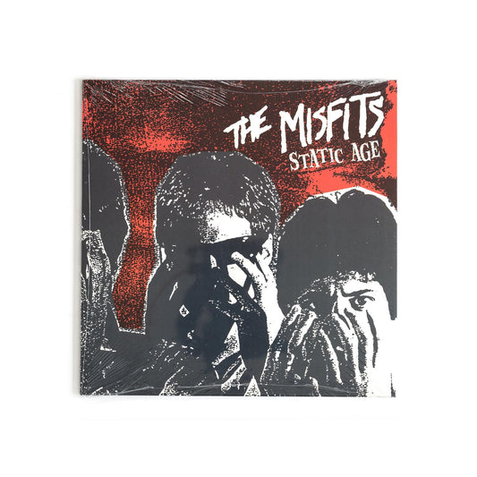 Album cover of Misfits – Static Age featuring bold red background, distorted band logo, and high-contrast black-and-white photo of the band, echoing 1970s punk aesthetics.
