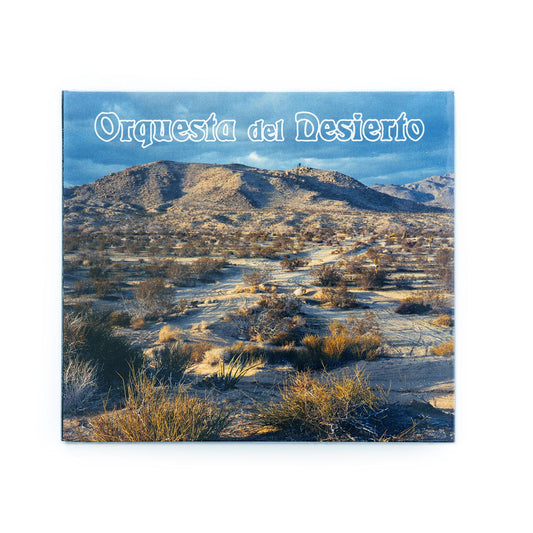 Orquesta Del Desierto self-titled CD front cover featuring a photo of a desert landscape with warm earth tones, cacti , and a serene blue sky; band name in elegant typography reflects the album’s blend of desert rock, Latin, and acoustic influences.